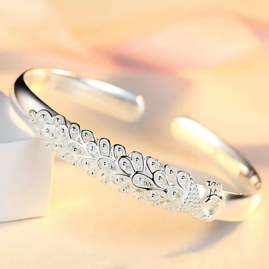 Alas de Plata: Pulsera Abierta con Detalles de Plumas